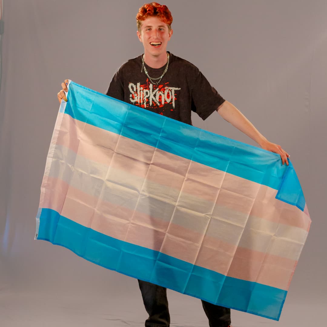 Justus Kornmesser, einer der Initiatoren von PrideLAB, präsentiert die große Trans-Pride-Flagge in 150x90 cm. Die Farben Hellblau, Rosa und Weiß des robusten Polyester-Stoffs sind klar erkennbar.