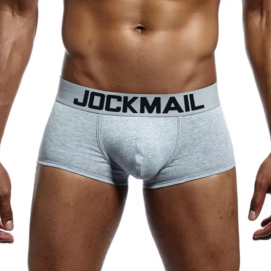 Nahaufnahme von figurbetonten Jockmail Boxer Briefs in Grau. Die Unterhose zeichnet sich durch einen formgebenden Frontbereich (Pouch) und einen markanten Logo-Bund aus.