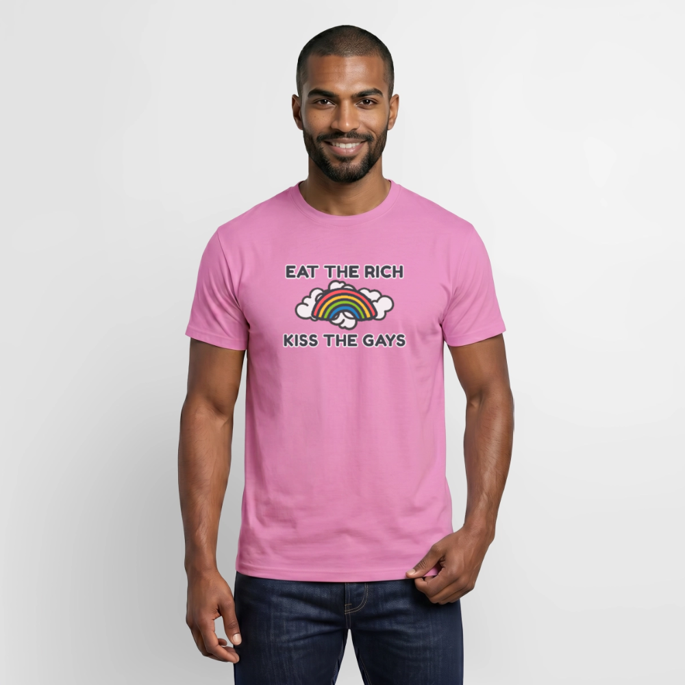 Ein lächelnder Mann trägt das pinke "Eat The Rich - Kiss The Gays" T-Shirt. Auf der Brust ist ein bunter Cartoon-Regenbogen mit weißen Wolken gedruckt, der queeren Aktivismus und Kapitalismuskritik humorvoll verbindet.